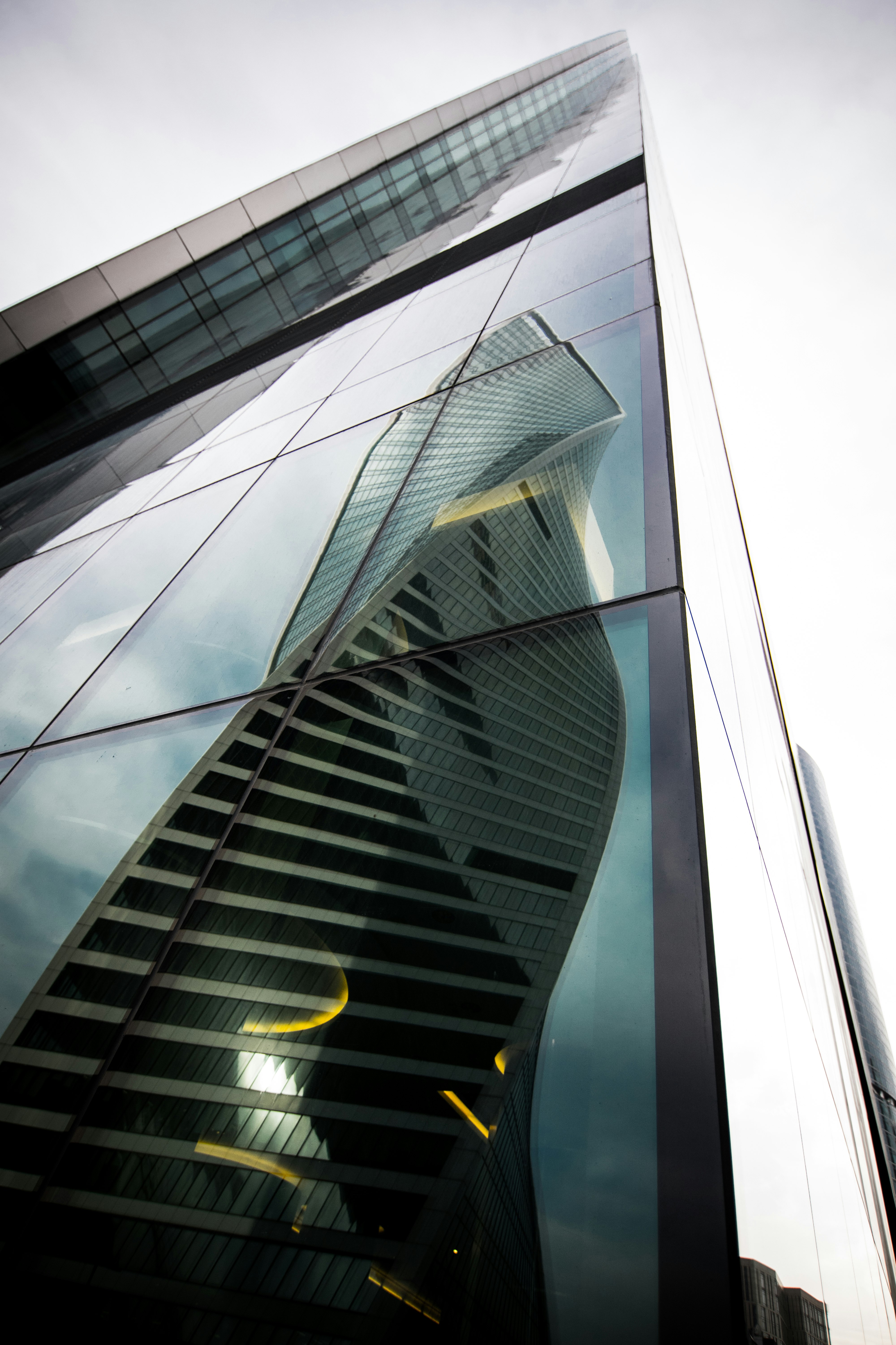 spiral high-rise building reflection on glass building